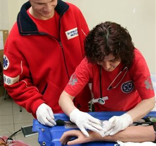 Studenci ratownictwa medycznego ćwiczą wkłucia na fantomie ręki